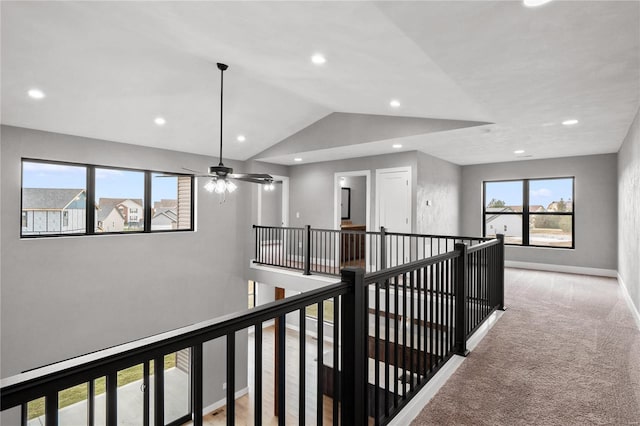 corridor featuring lofted ceiling and light carpet