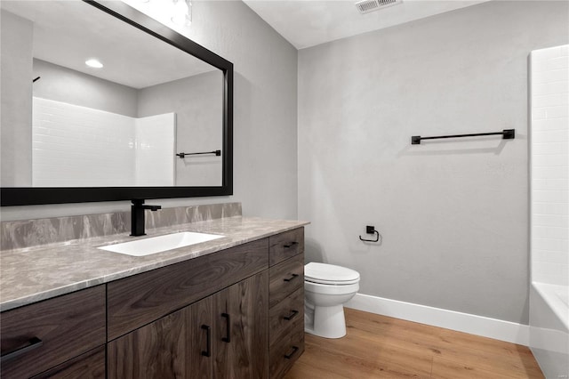 bathroom featuring vanity, hardwood / wood-style flooring, and toilet