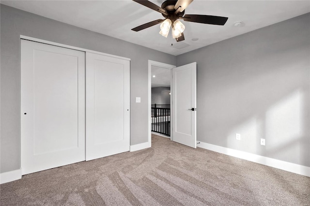 unfurnished bedroom with light carpet, ceiling fan, and a closet