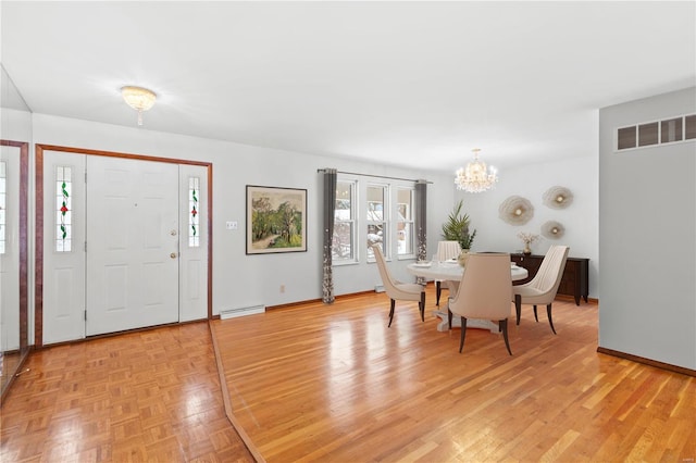 entrance foyer featuring light hardwood / wood-style floors, a notable chandelier, and a baseboard heating unit