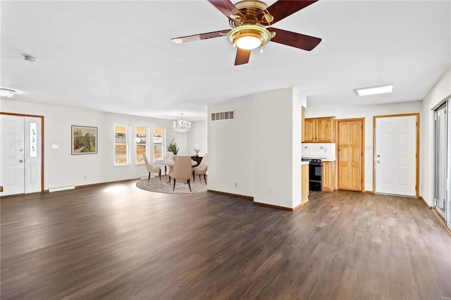 unfurnished living room featuring ceiling fan with notable chandelier and dark hardwood / wood-style flooring