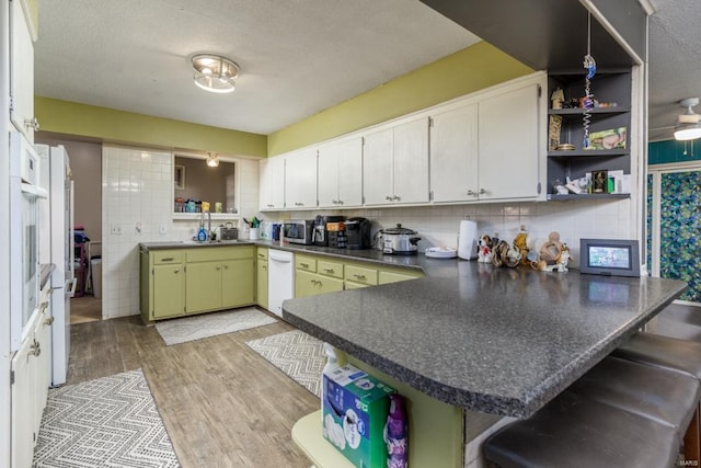 kitchen featuring a kitchen breakfast bar, kitchen peninsula, and white cabinetry