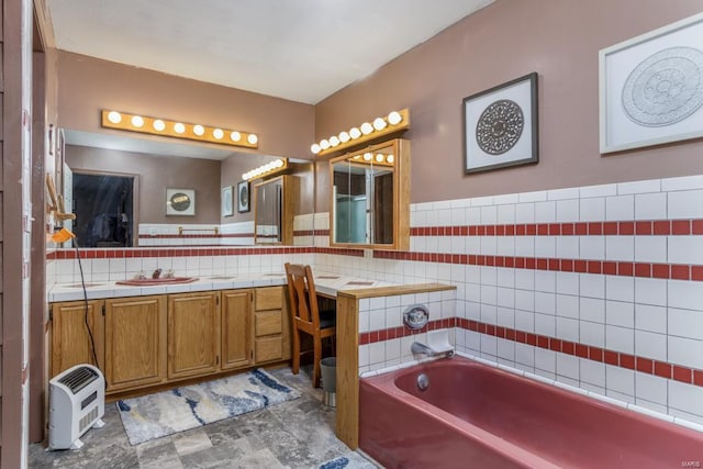 bathroom featuring a washtub, vanity, and tile walls