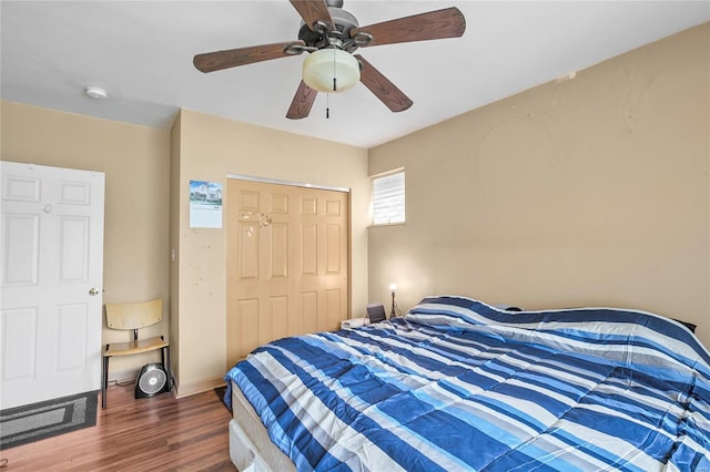 bedroom featuring dark hardwood / wood-style flooring, ceiling fan, and a closet