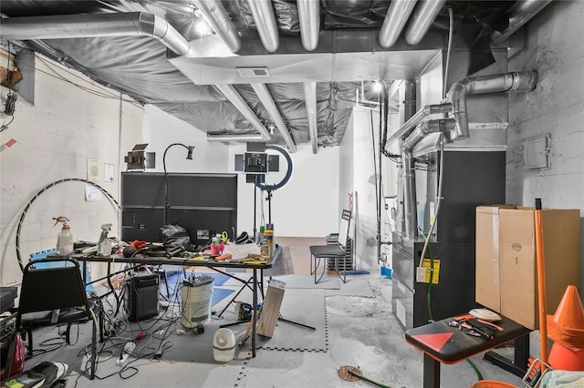 basement featuring a workshop area and heating unit