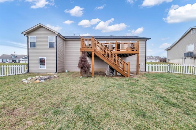 back of house featuring a lawn and a deck