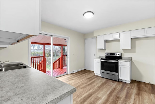 kitchen with electric range, light hardwood / wood-style flooring, white cabinetry, and sink