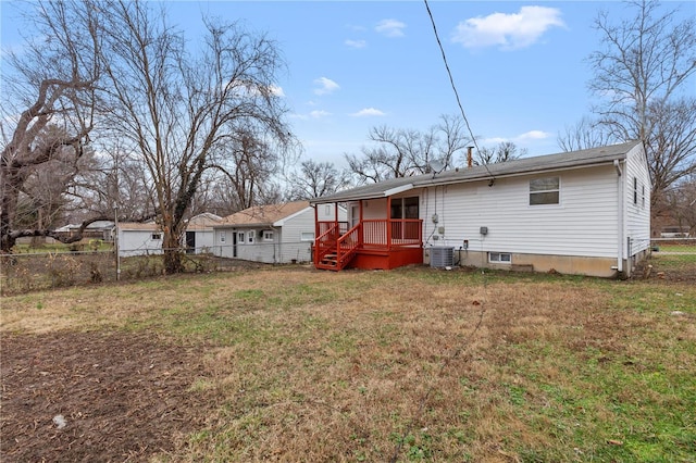 back of property with central AC unit and a lawn