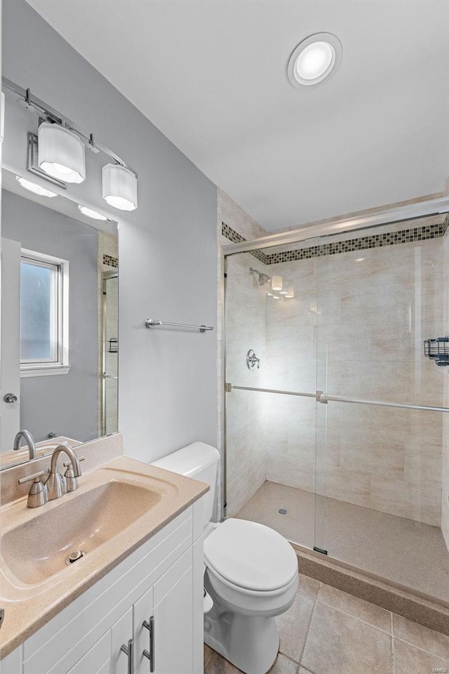 bathroom featuring walk in shower, tile patterned floors, vanity, and toilet