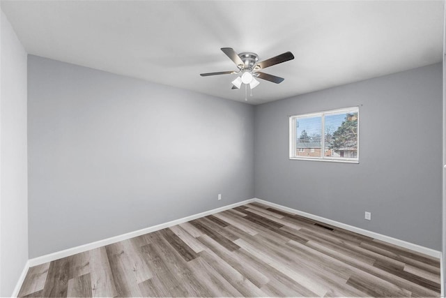 empty room with ceiling fan and light hardwood / wood-style flooring