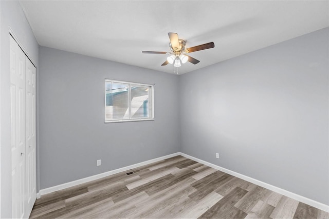 unfurnished bedroom with light hardwood / wood-style floors, a closet, and ceiling fan