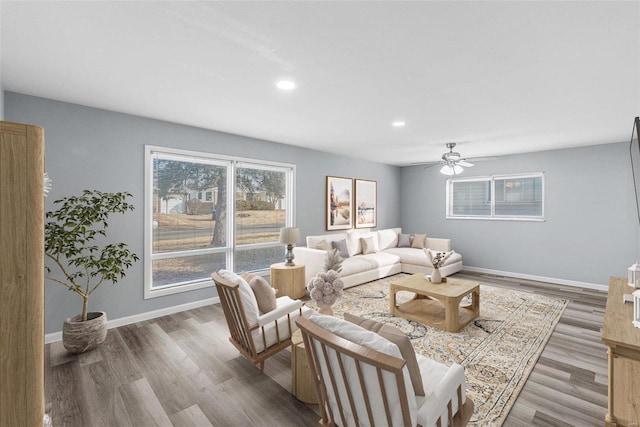 living room featuring wood-type flooring and ceiling fan