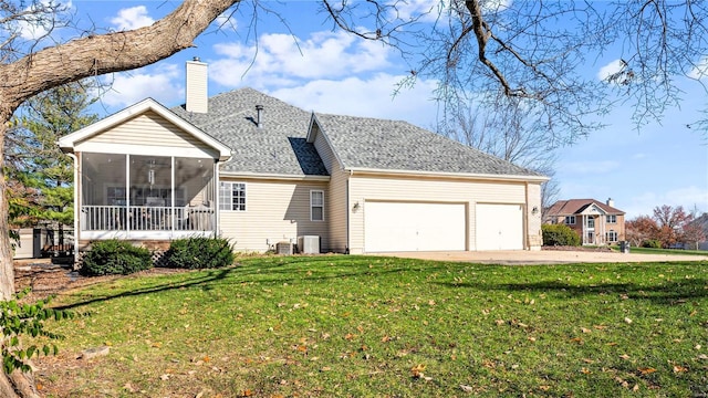 rear view of house featuring a sunroom, central AC unit, a garage, and a yard