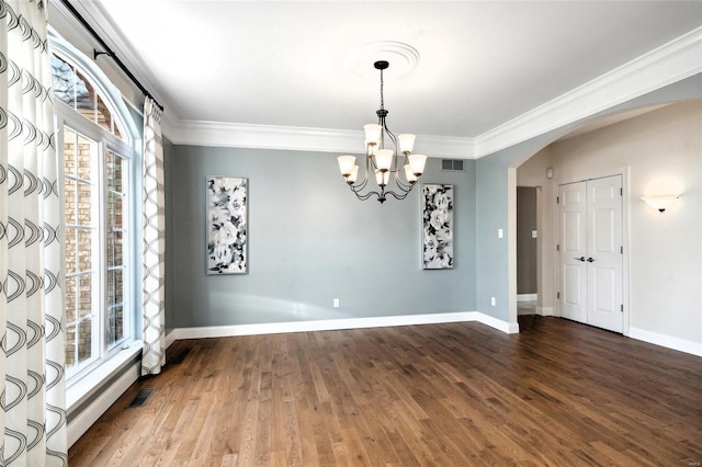 empty room featuring hardwood / wood-style floors, a chandelier, and ornamental molding