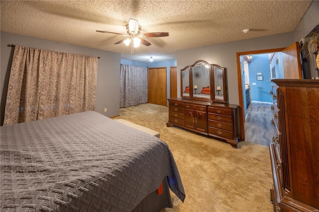 carpeted bedroom with a textured ceiling and ceiling fan