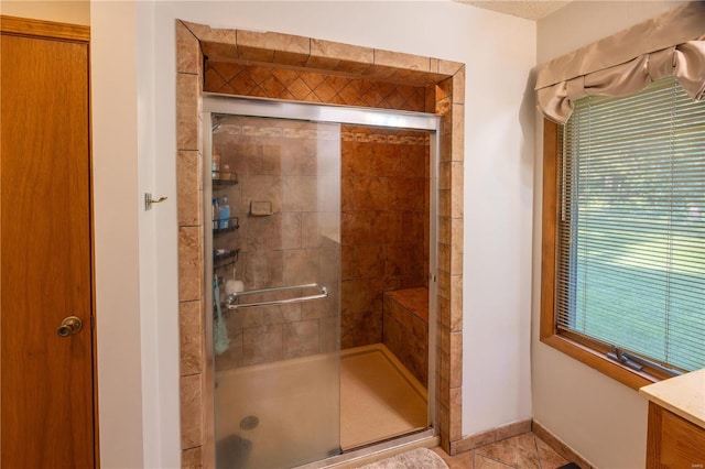 bathroom featuring tile patterned flooring, vanity, and a shower with door