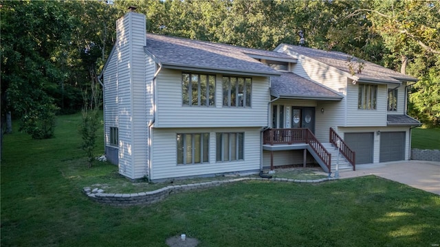 raised ranch with a front lawn and a garage