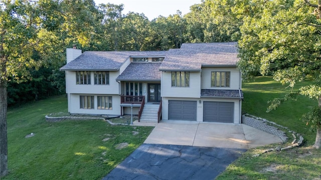 bi-level home featuring a garage and a front lawn