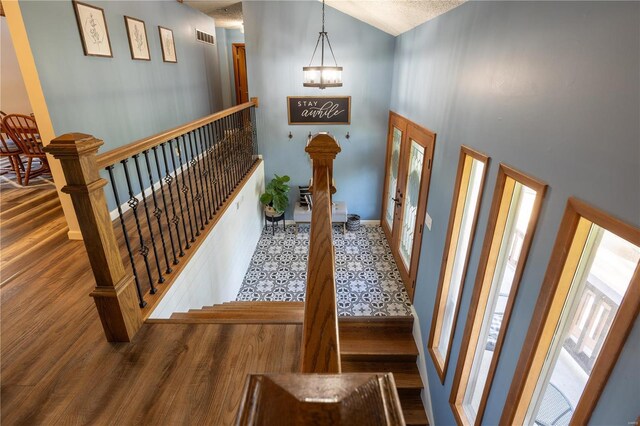 foyer with hardwood / wood-style flooring and high vaulted ceiling