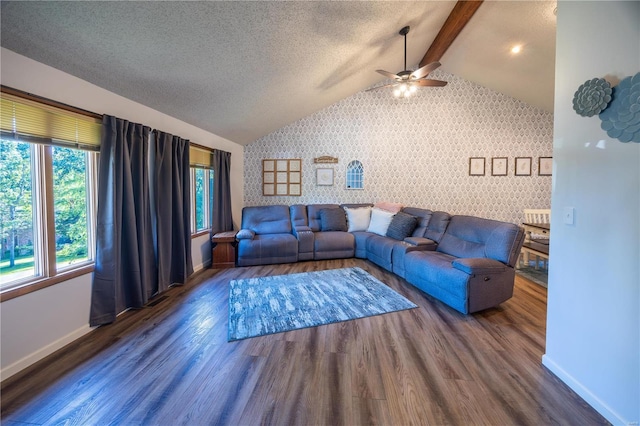 living room with ceiling fan, vaulted ceiling with beams, dark wood-type flooring, and a textured ceiling