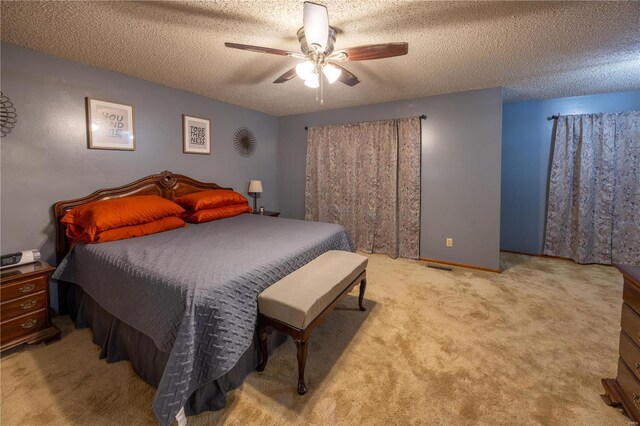 bedroom featuring ceiling fan, light colored carpet, and a textured ceiling