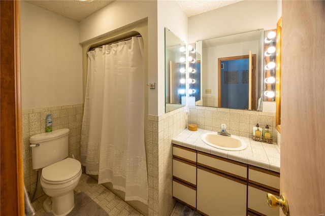 bathroom featuring tile patterned floors, toilet, a shower with curtain, tile walls, and vanity