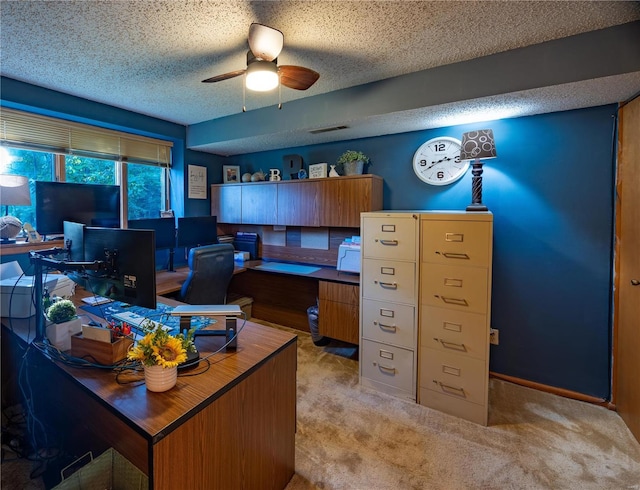 office area featuring ceiling fan, light carpet, and a textured ceiling