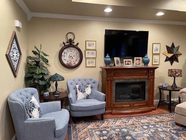 sitting room with wood-type flooring and crown molding