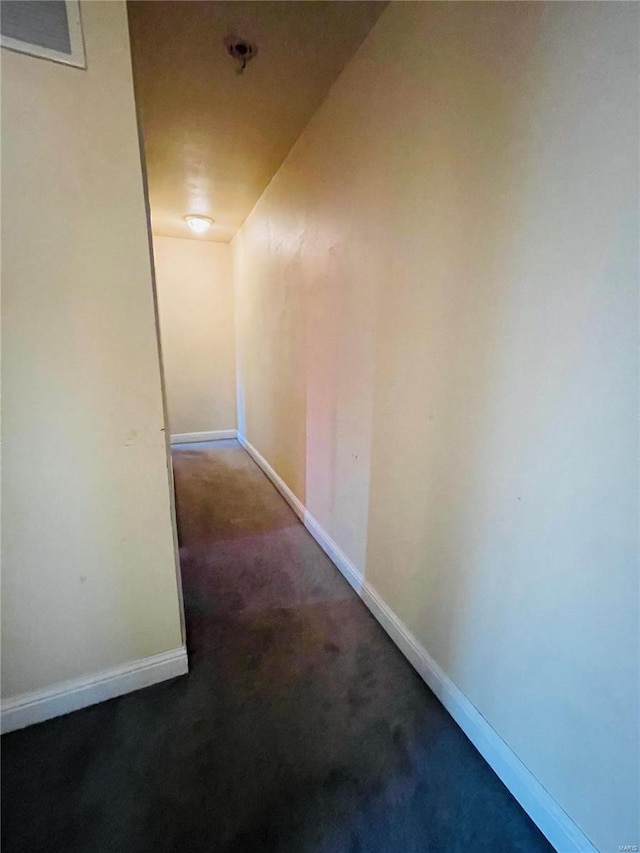 hallway featuring dark carpet