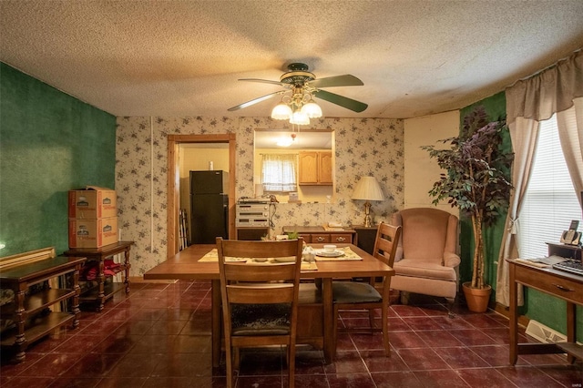 tiled dining room with ceiling fan and a textured ceiling