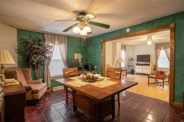 tiled dining area featuring ceiling fan and a textured ceiling