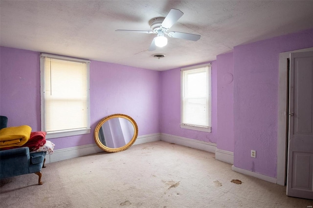 interior space with ceiling fan and light colored carpet