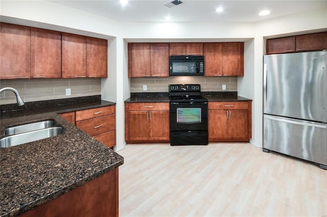 kitchen featuring black appliances, decorative backsplash, sink, and light hardwood / wood-style flooring