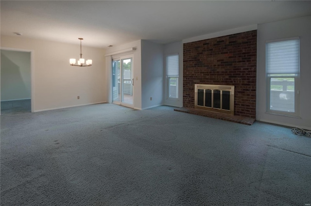 unfurnished living room featuring a fireplace, carpet, and an inviting chandelier