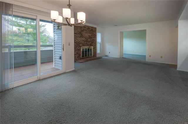 unfurnished living room featuring carpet floors, a fireplace, and a chandelier