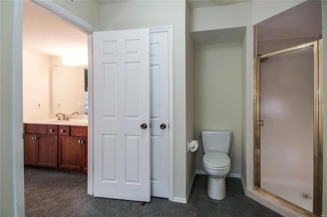 bathroom featuring vanity, toilet, and a shower with door