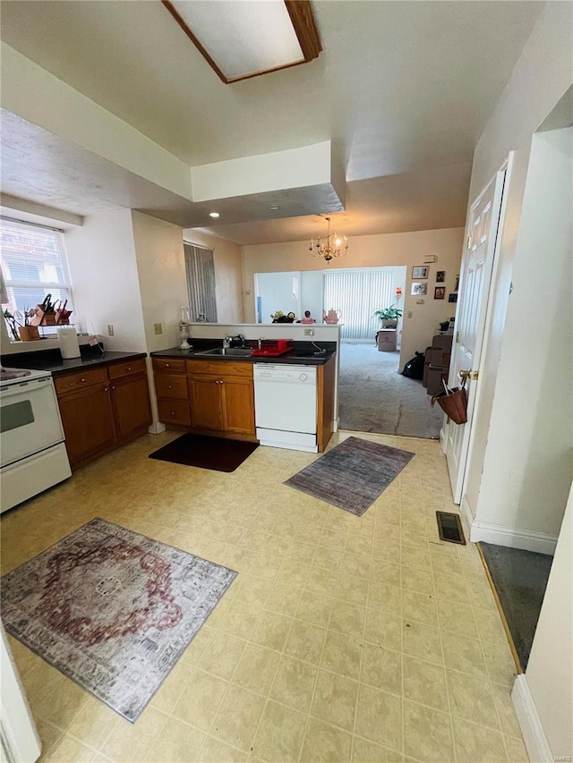 kitchen with sink, white appliances, and a notable chandelier