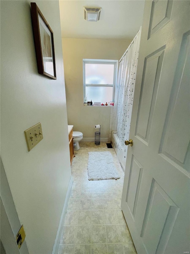 full bathroom with shower / tub combo with curtain, vanity, and toilet