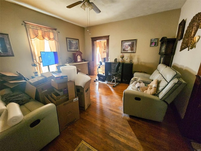 living room featuring dark hardwood / wood-style flooring and ceiling fan