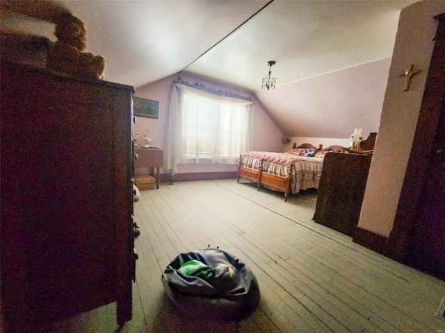 bedroom with hardwood / wood-style floors and vaulted ceiling