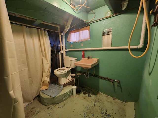 bathroom featuring concrete flooring, toilet, and sink