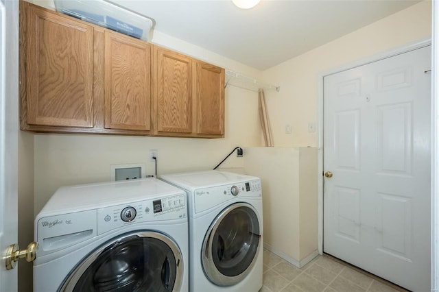 laundry room with washing machine and dryer and cabinets