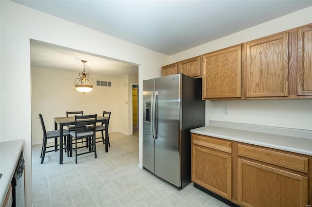 kitchen with decorative light fixtures and stainless steel refrigerator with ice dispenser