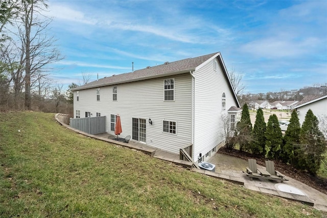 rear view of property featuring a lawn and a patio area