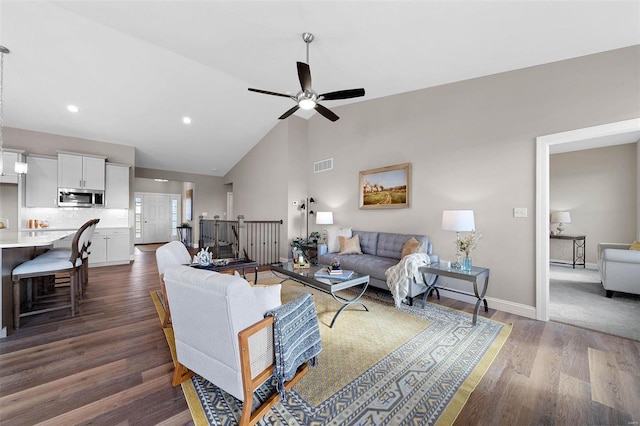 living room featuring dark wood-type flooring, high vaulted ceiling, and ceiling fan