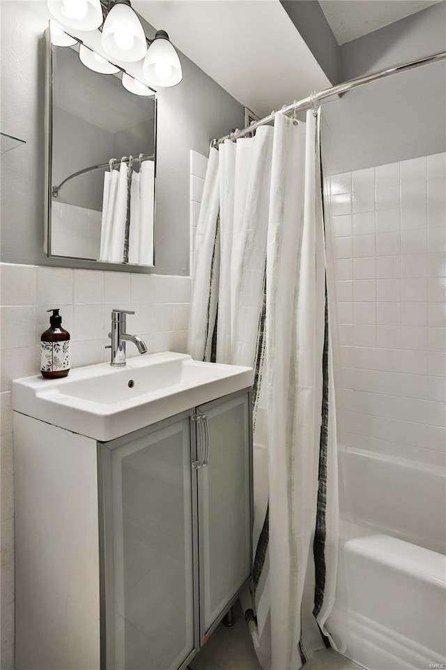 bathroom with decorative backsplash, vanity, shower / tub combo with curtain, and tile walls