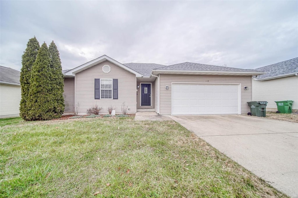 ranch-style home with a garage and a front lawn