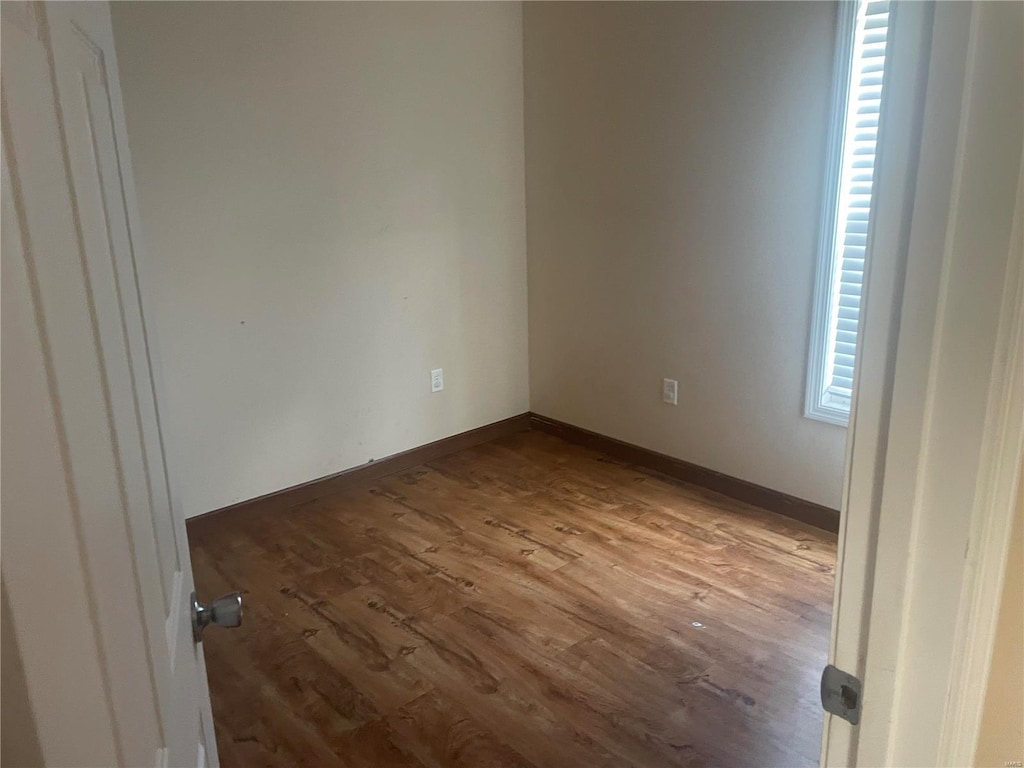 unfurnished room with wood-type flooring