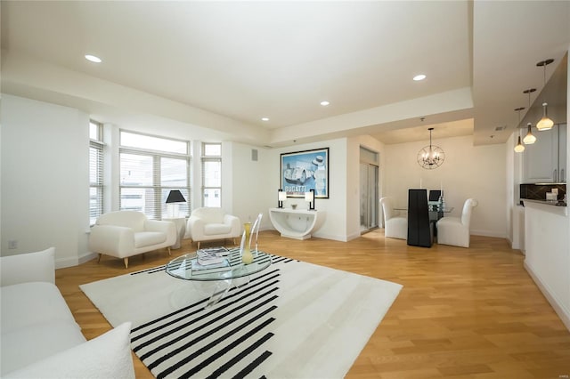 living room featuring a chandelier and light hardwood / wood-style floors