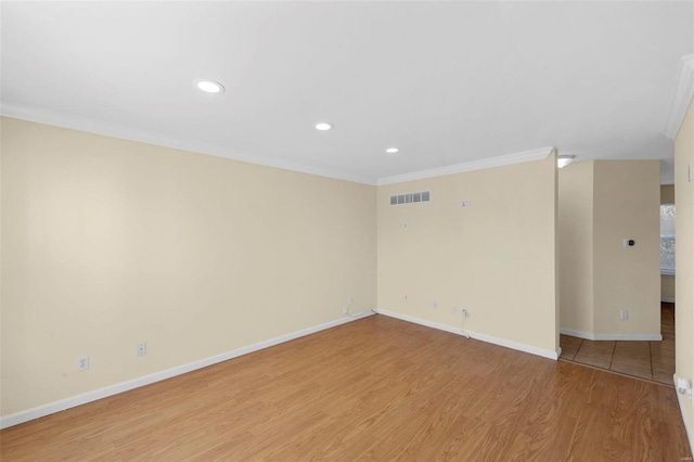 unfurnished room featuring crown molding and light wood-type flooring